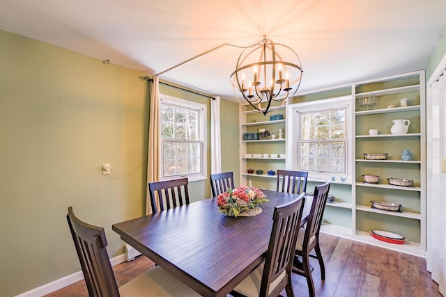 dining area with wood-type flooring and a notable chandelier