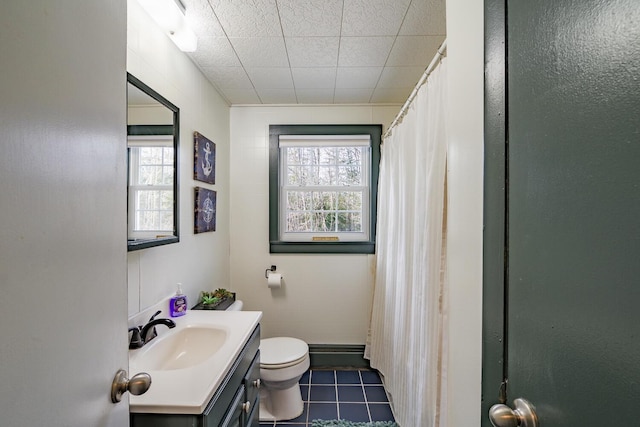 bathroom featuring toilet, vanity, a shower with curtain, and tile patterned floors