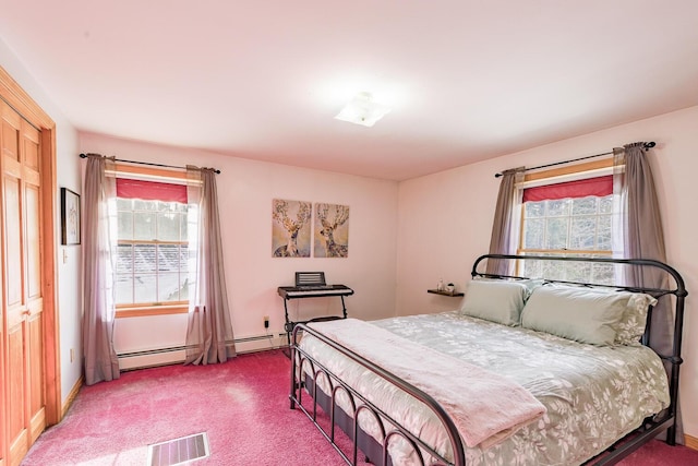 bedroom with baseboard heating, multiple windows, and carpet