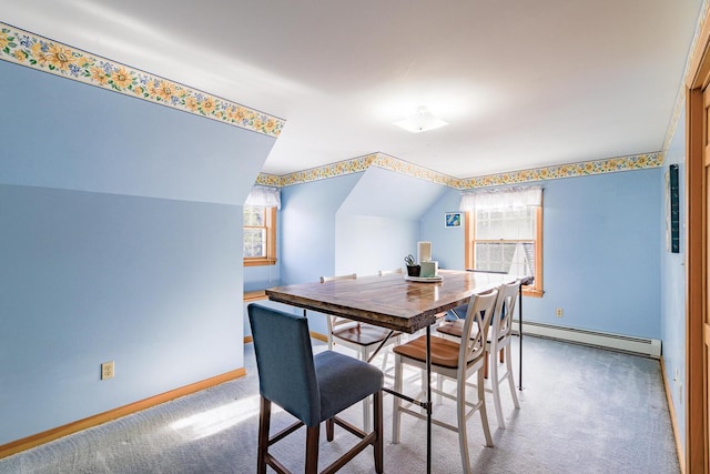 dining area with carpet floors, baseboard heating, a wealth of natural light, and vaulted ceiling