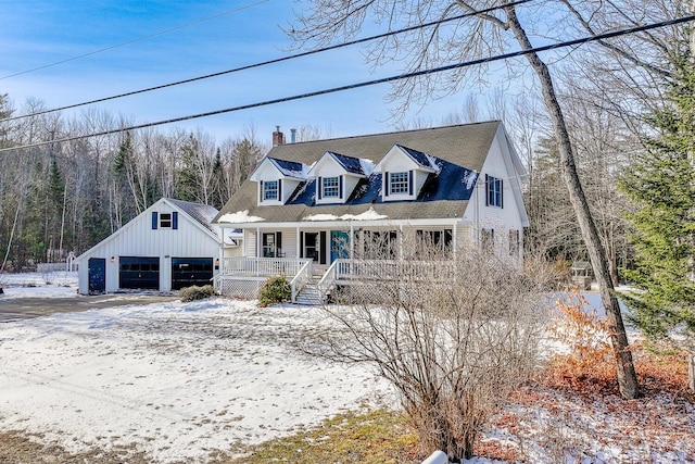 cape cod-style house featuring a garage, an outbuilding, and covered porch