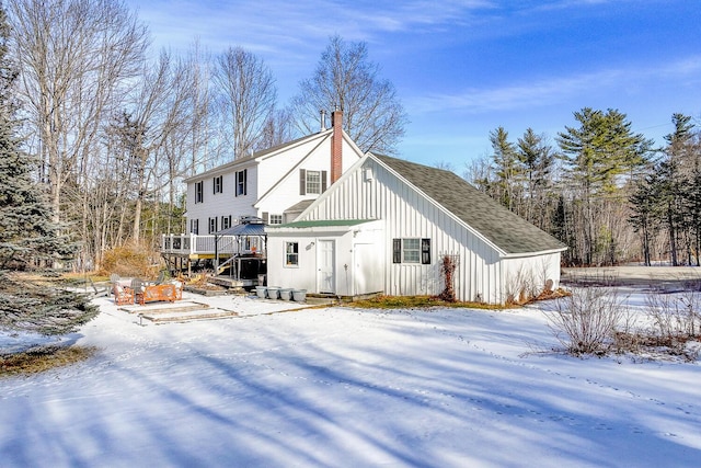 view of snow covered back of property