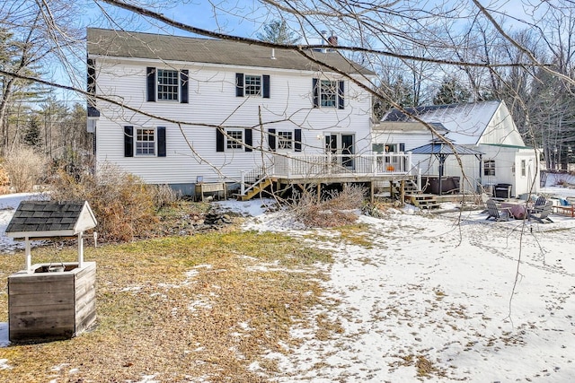 snow covered rear of property with a wooden deck and a gazebo