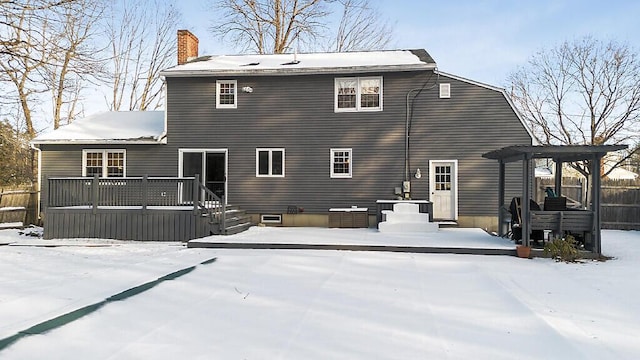 snow covered rear of property featuring a pergola