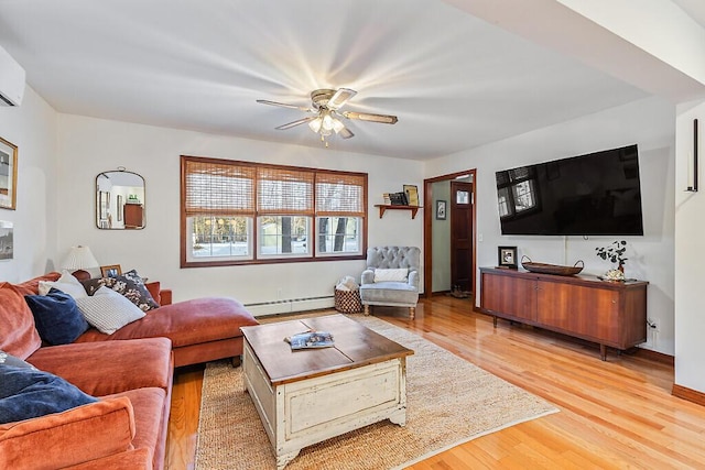 living room with a baseboard heating unit, ceiling fan, and light hardwood / wood-style flooring