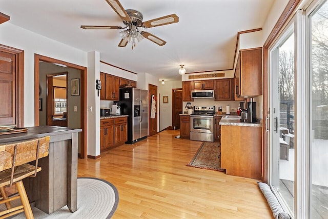 kitchen featuring ceiling fan, light hardwood / wood-style flooring, and appliances with stainless steel finishes