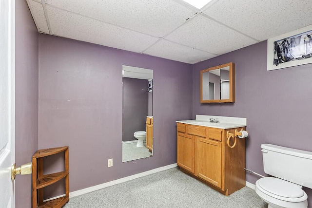 bathroom featuring a paneled ceiling, vanity, and toilet