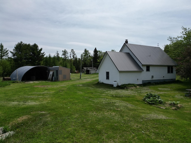 view of home's exterior featuring a yard and an outbuilding