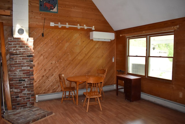 dining room with baseboard heating, lofted ceiling, wood-type flooring, and an AC wall unit