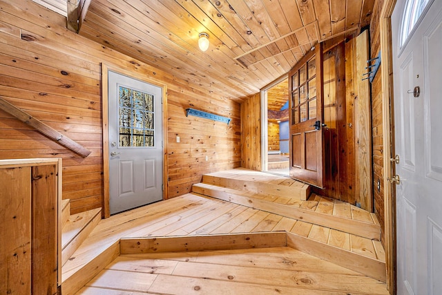 mudroom featuring wood-type flooring, wood walls, vaulted ceiling, and wood ceiling