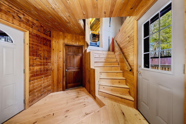 entryway featuring wood ceiling, light hardwood / wood-style flooring, and wooden walls