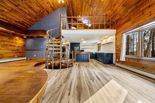 unfurnished living room with wooden ceiling, wood walls, baseboard heating, and light wood-type flooring