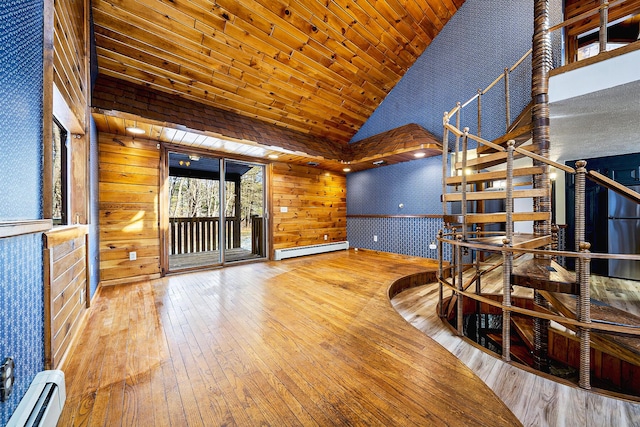 unfurnished living room featuring high vaulted ceiling, wooden walls, and a baseboard radiator