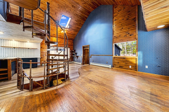 interior space featuring high vaulted ceiling, a baseboard heating unit, a skylight, and wood-type flooring