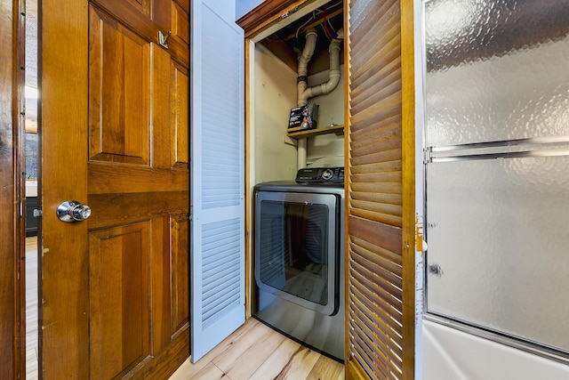 laundry room with light hardwood / wood-style floors, washer / clothes dryer, and log walls