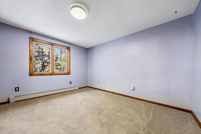 spare room with a baseboard heating unit, a textured ceiling, and carpet floors