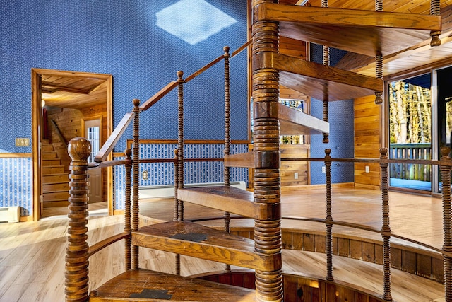 staircase featuring wooden ceiling and wooden walls