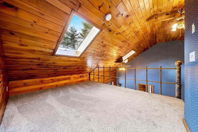 bonus room featuring lofted ceiling with skylight, wooden ceiling, wood walls, and carpet flooring