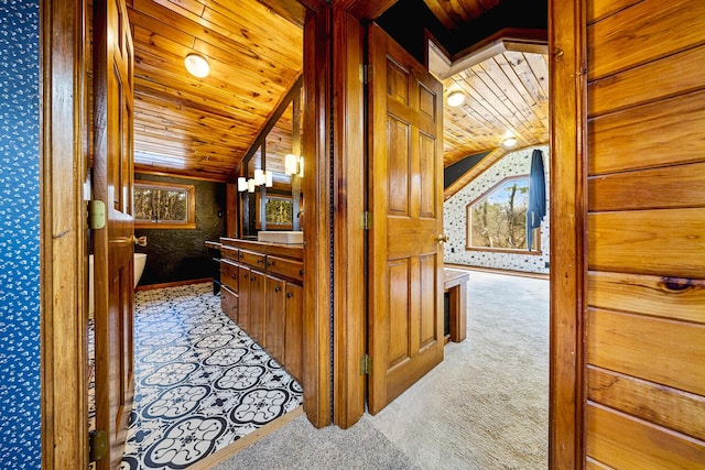 hallway featuring lofted ceiling, wood ceiling, and light colored carpet