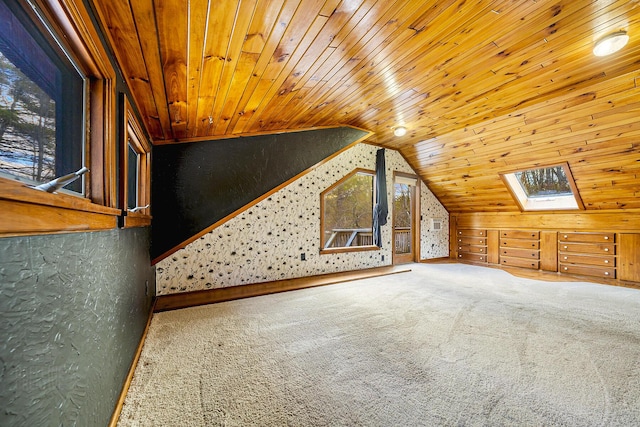 additional living space with wooden ceiling, lofted ceiling with skylight, and carpet