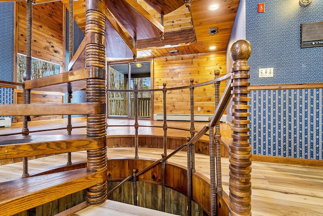 stairs featuring a baseboard radiator, wooden ceiling, and hardwood / wood-style floors