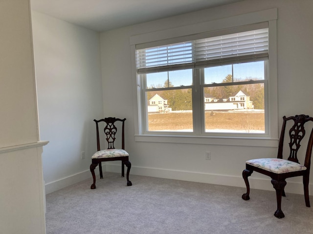 living area with plenty of natural light and light colored carpet