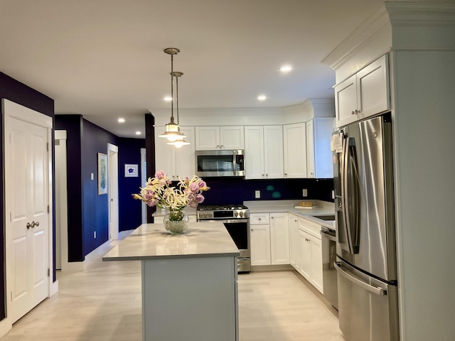 kitchen with appliances with stainless steel finishes, hanging light fixtures, light hardwood / wood-style floors, a center island, and white cabinets