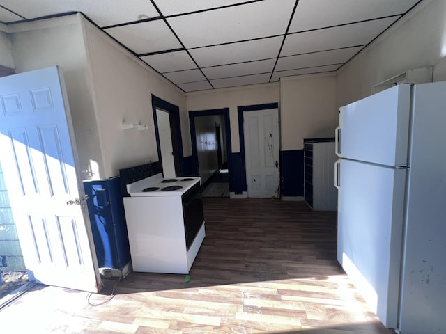 kitchen featuring dark wood-type flooring, white appliances, and a paneled ceiling