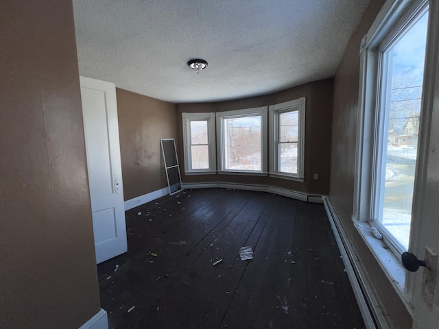 empty room featuring a textured ceiling and dark hardwood / wood-style flooring