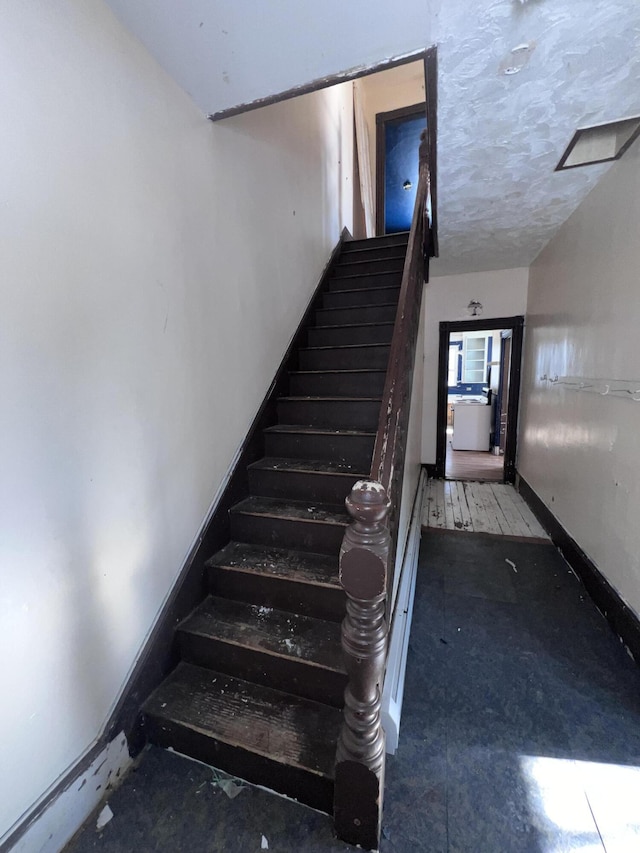 staircase with a textured ceiling