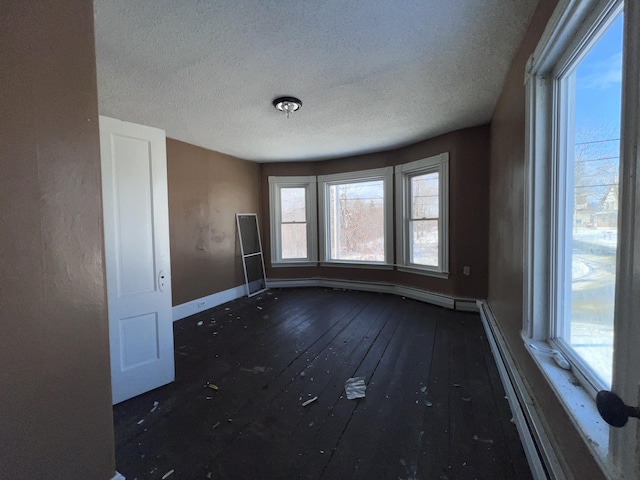 spare room featuring dark wood-type flooring and a textured ceiling