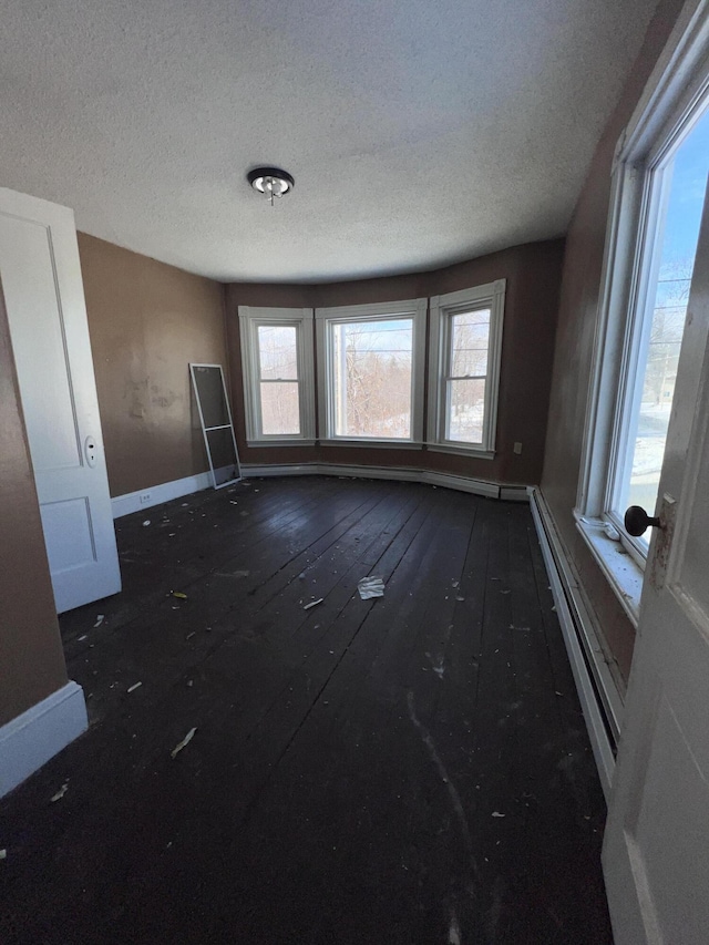 interior space featuring a textured ceiling and a baseboard heating unit