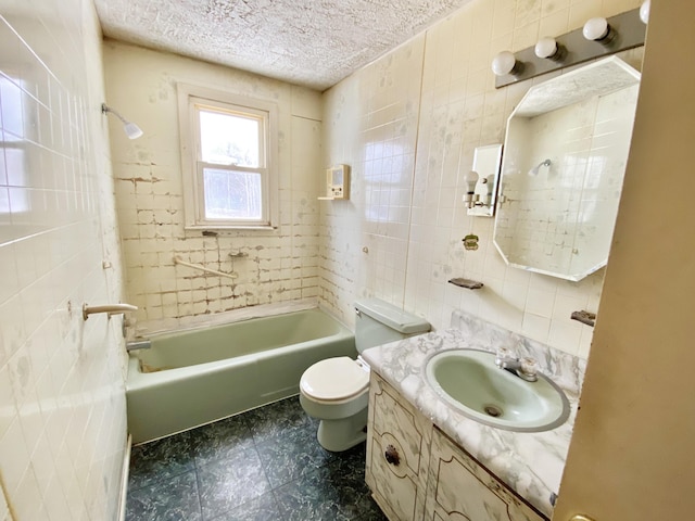 full bathroom featuring toilet, vanity, tile walls, tiled shower / bath, and a textured ceiling