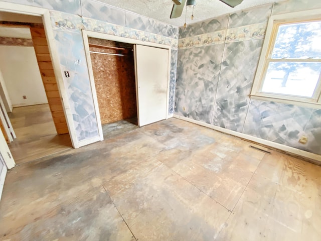 unfurnished bedroom featuring ceiling fan and a closet