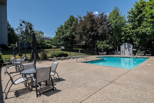 view of pool featuring a patio area and a storage unit