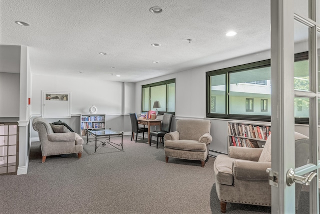 carpeted living room with a textured ceiling and a baseboard radiator