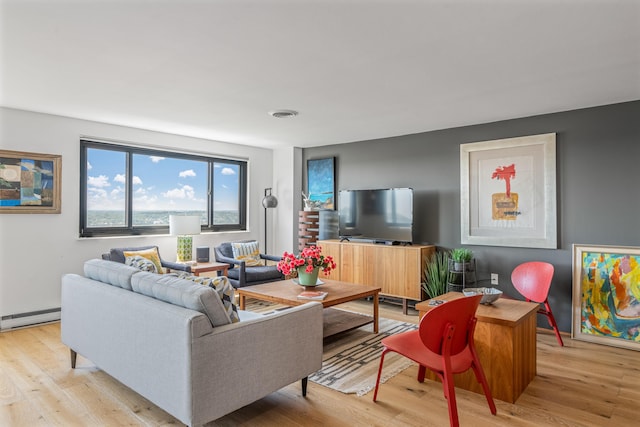 living room with baseboard heating and light wood-type flooring