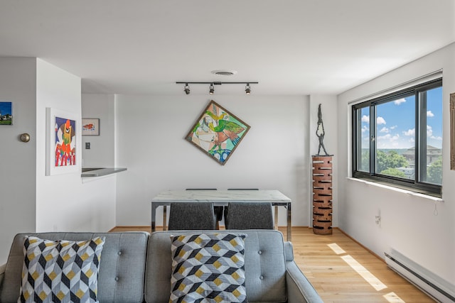 dining space featuring light hardwood / wood-style floors, track lighting, and a baseboard radiator