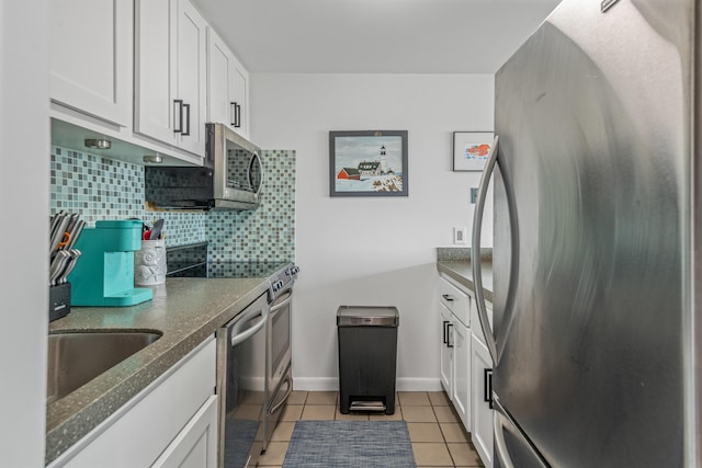 kitchen with white cabinets, appliances with stainless steel finishes, and light tile patterned floors