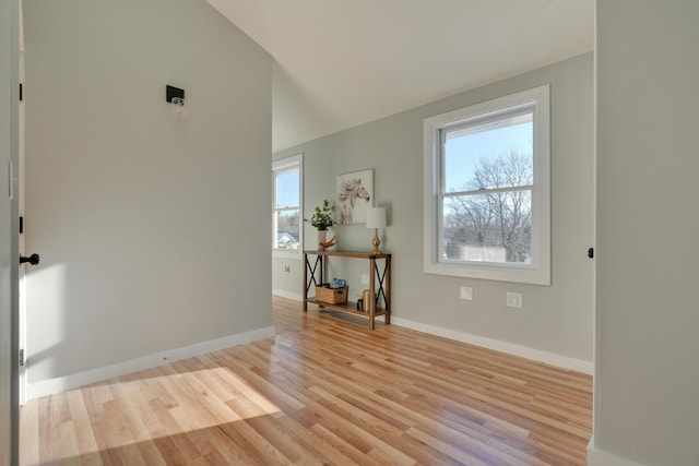 interior space with vaulted ceiling and light hardwood / wood-style flooring