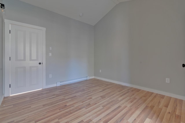 unfurnished room with lofted ceiling, a baseboard heating unit, and light hardwood / wood-style flooring