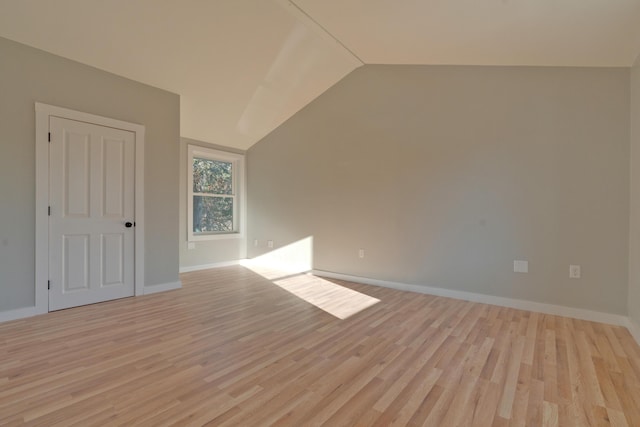 additional living space featuring vaulted ceiling and light hardwood / wood-style flooring