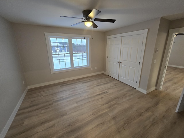 unfurnished bedroom featuring ceiling fan, a closet, and light hardwood / wood-style floors