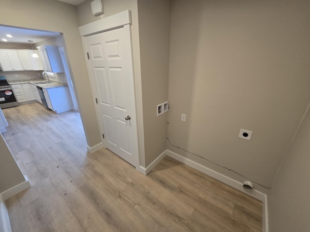 laundry area with sink, hookup for a washing machine, electric dryer hookup, and light hardwood / wood-style flooring