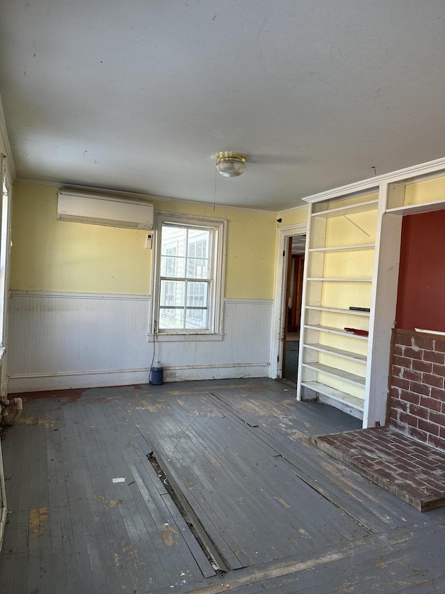 unfurnished bedroom featuring an AC wall unit