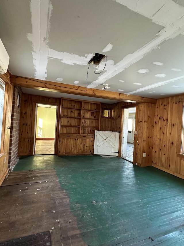 unfurnished living room with wooden walls, dark hardwood / wood-style floors, and beamed ceiling