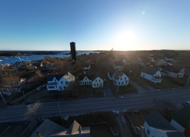 aerial view at dusk featuring a water view