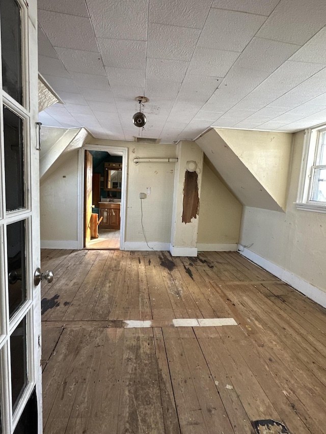 bonus room with wood-type flooring and lofted ceiling