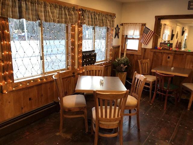 dining space featuring wood walls