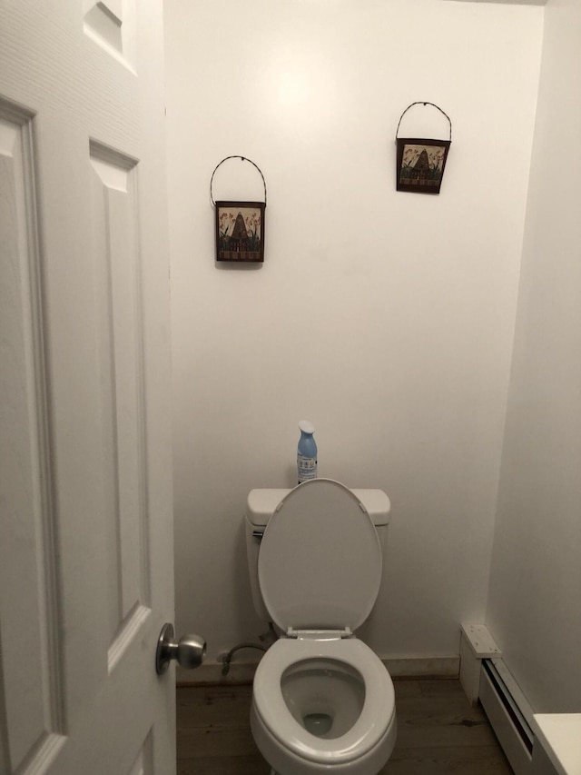 bathroom featuring toilet, baseboard heating, and hardwood / wood-style floors